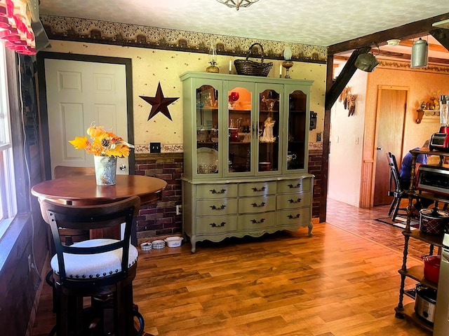 dining room with hardwood / wood-style flooring and a textured ceiling