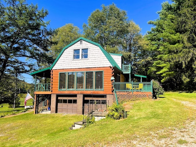 back of house featuring a wooden deck, a garage, and a yard