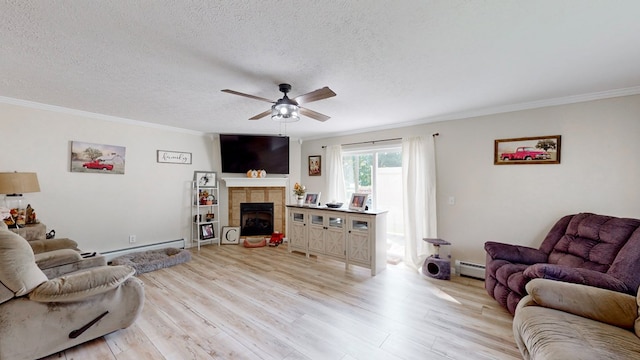 living room featuring a tiled fireplace, a baseboard radiator, ornamental molding, and light wood-type flooring