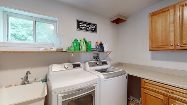 washroom with sink, cabinets, and washing machine and clothes dryer