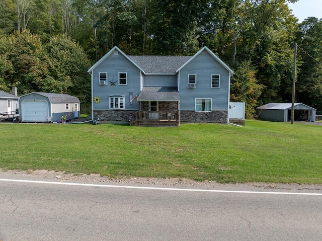 view of front of property featuring a garage, an outbuilding, a front yard, and a porch