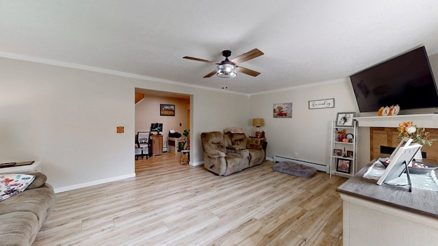 living room with a tile fireplace, ornamental molding, light wood-type flooring, and baseboard heating