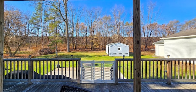 wooden deck featuring a storage unit and a lawn