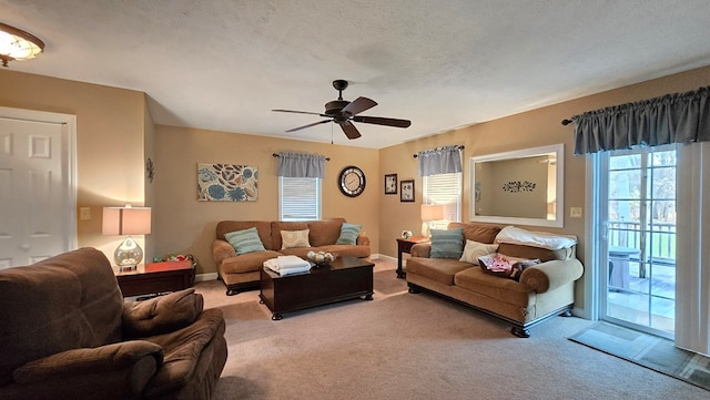 living room with ceiling fan, carpet floors, and a textured ceiling