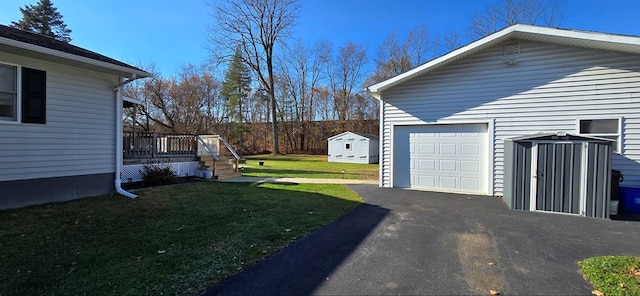 view of yard featuring a garage, an outdoor structure, and a deck