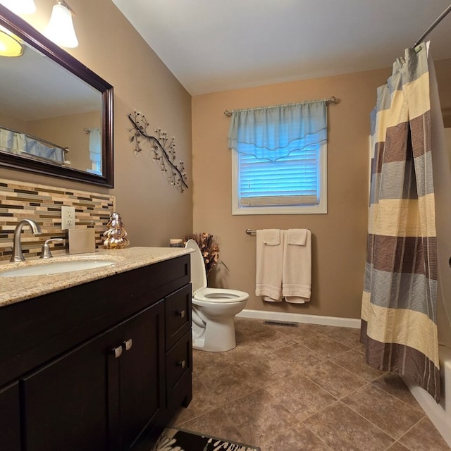 bathroom featuring tasteful backsplash, vanity, and toilet