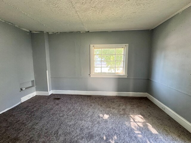 carpeted spare room with a textured ceiling