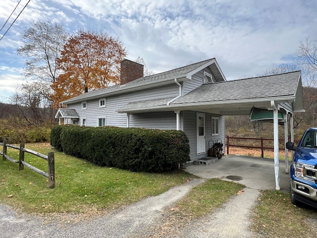 view of home's exterior with a carport and a lawn