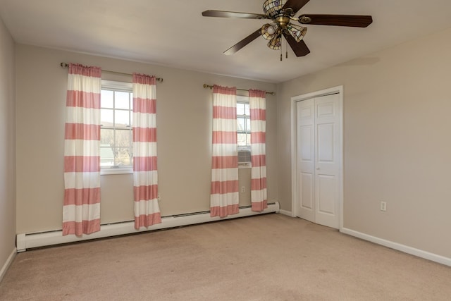 unfurnished bedroom featuring light carpet, a baseboard heating unit, a closet, and ceiling fan