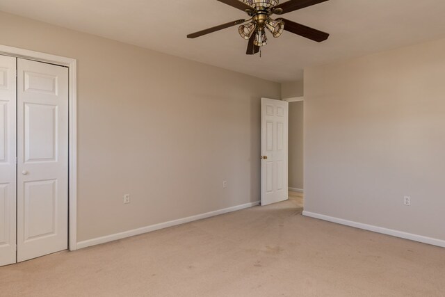 unfurnished bedroom featuring light colored carpet, a closet, and ceiling fan