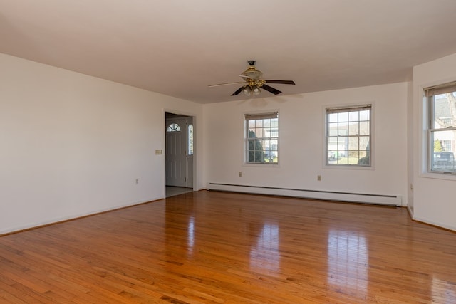 spare room with a baseboard radiator, ceiling fan, and light hardwood / wood-style flooring