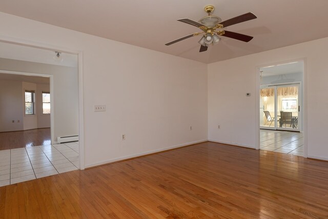 unfurnished room featuring ceiling fan, a baseboard radiator, and light hardwood / wood-style floors