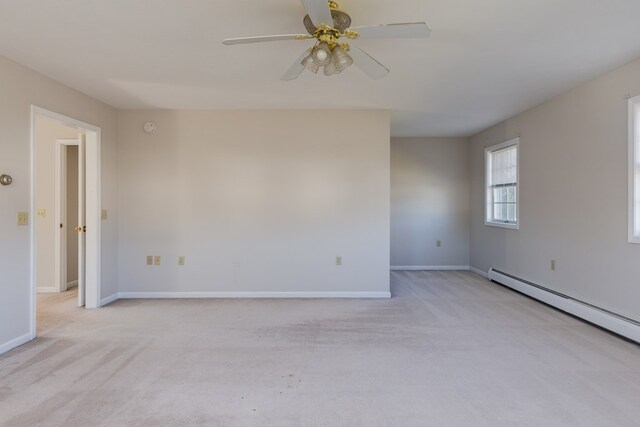 carpeted spare room featuring baseboard heating and ceiling fan