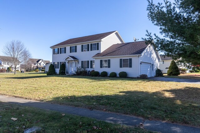 colonial home featuring a garage and a front yard