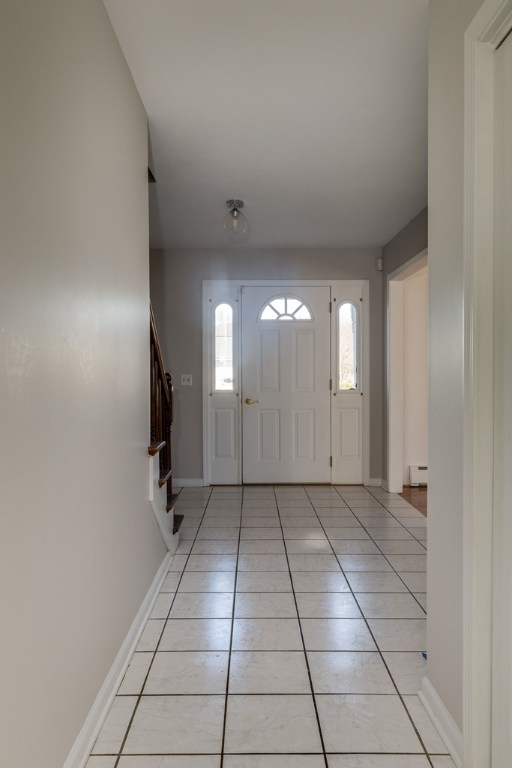 entrance foyer featuring light tile patterned flooring and baseboard heating