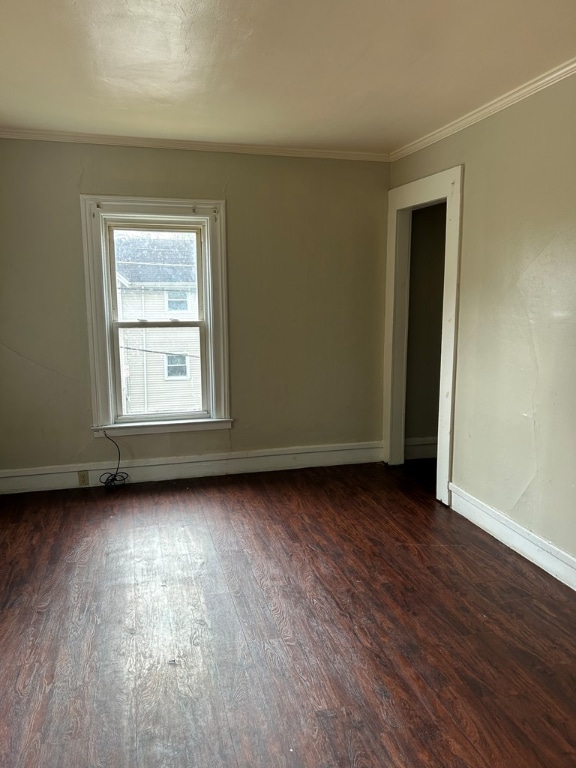 spare room featuring dark hardwood / wood-style flooring and ornamental molding