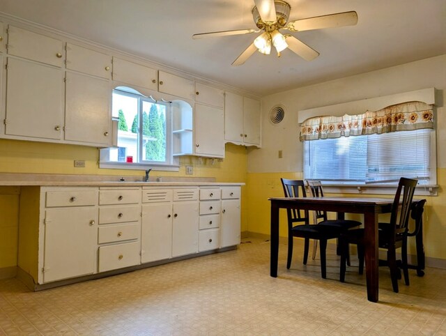 kitchen featuring white cabinetry, sink, and ceiling fan