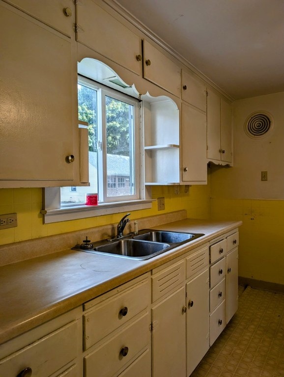 kitchen featuring white cabinetry and sink