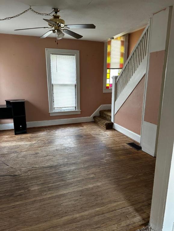 unfurnished living room with ceiling fan, plenty of natural light, and dark hardwood / wood-style floors