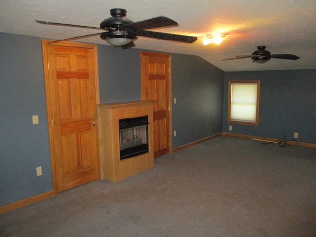 unfurnished living room featuring a multi sided fireplace, vaulted ceiling, carpet flooring, and ceiling fan