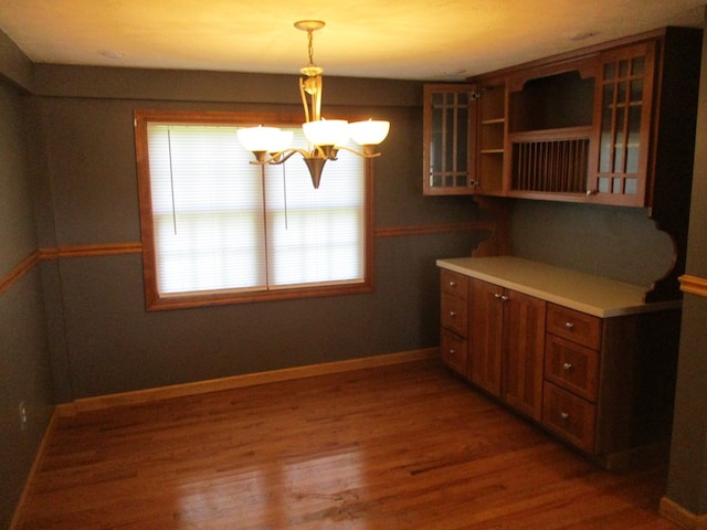 kitchen featuring a notable chandelier, decorative light fixtures, and dark wood-type flooring