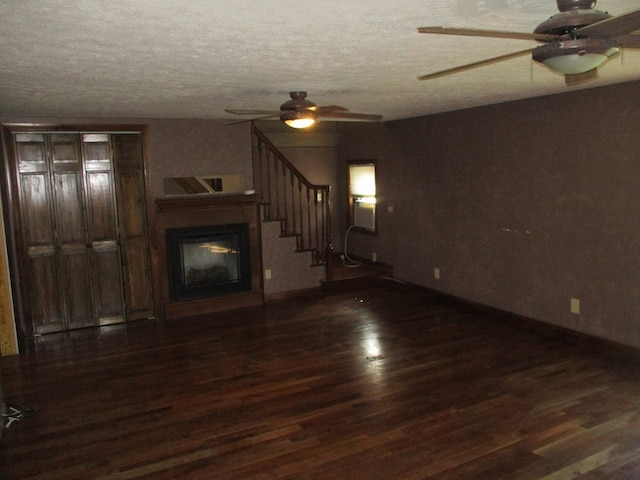 unfurnished living room with ceiling fan, a textured ceiling, and dark hardwood / wood-style flooring