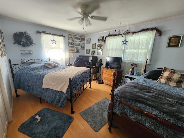 bedroom featuring ceiling fan, ornamental molding, and hardwood / wood-style floors