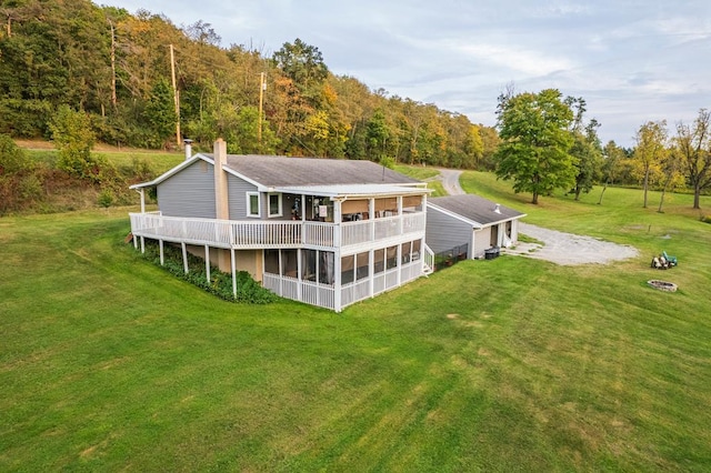 back of property featuring a sunroom and a lawn