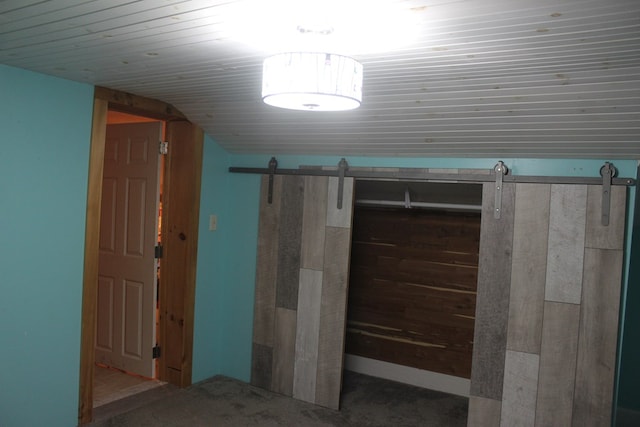 interior space with a barn door and wooden ceiling