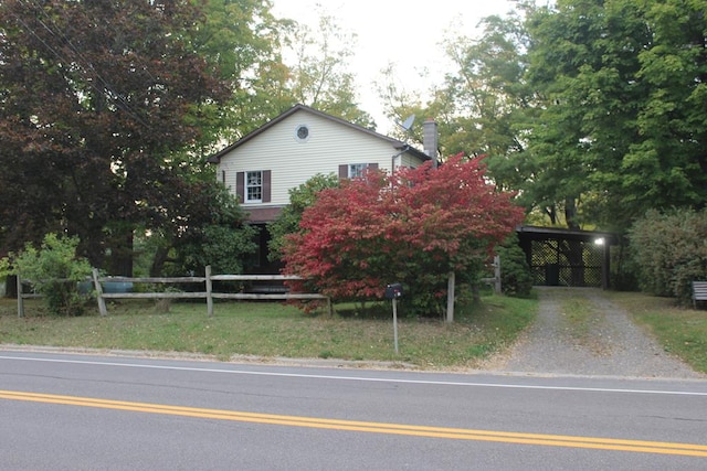 view of property hidden behind natural elements featuring a carport