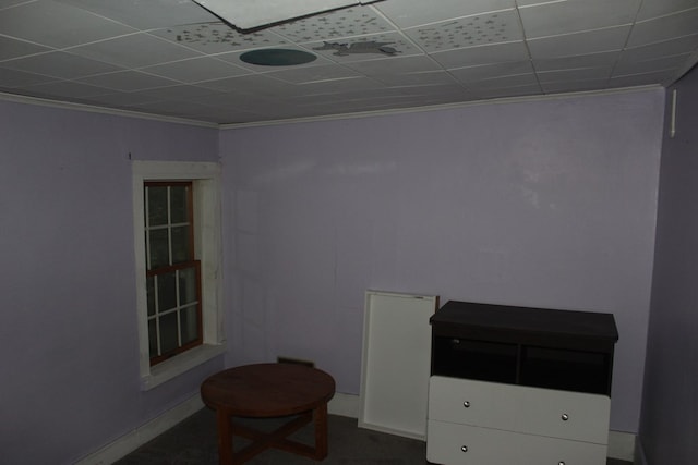 interior space with a paneled ceiling and ornamental molding