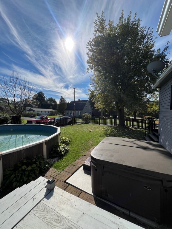 view of yard featuring a swimming pool with hot tub