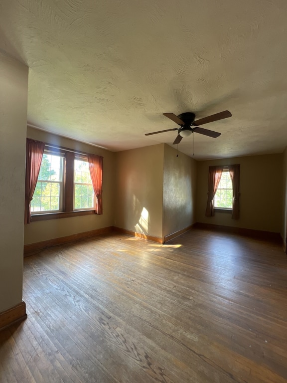 unfurnished room with ceiling fan, hardwood / wood-style floors, and a textured ceiling