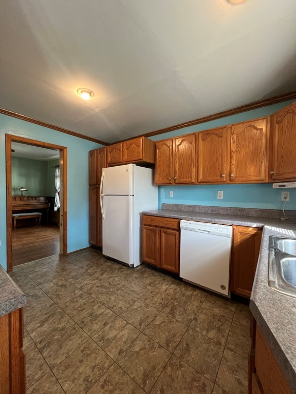 kitchen with white appliances, ornamental molding, and sink