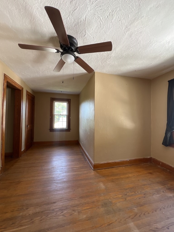 spare room with a textured ceiling and dark hardwood / wood-style flooring