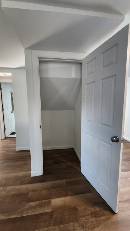 bonus room with dark hardwood / wood-style flooring and vaulted ceiling