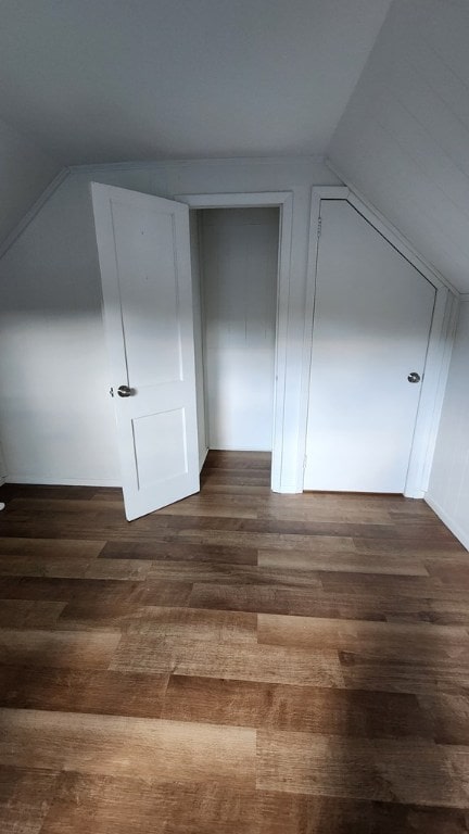 bonus room with lofted ceiling and dark hardwood / wood-style flooring