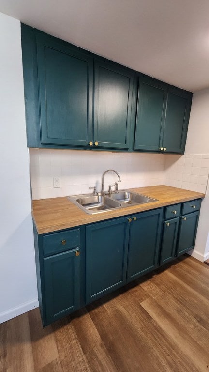 kitchen featuring tasteful backsplash, wood counters, wood-type flooring, and sink