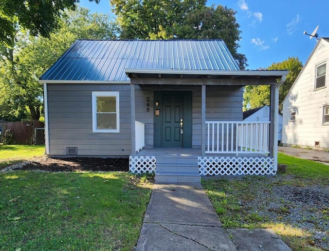 bungalow featuring covered porch and a front yard