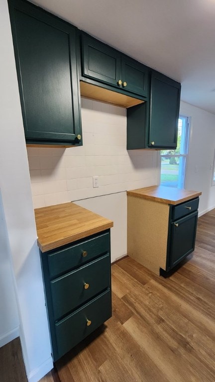 kitchen with backsplash, wood-type flooring, and green cabinets