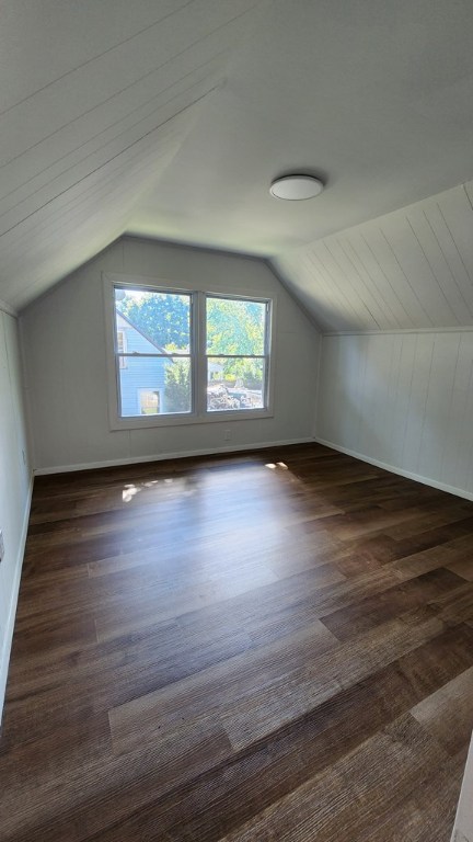 bonus room with lofted ceiling and dark hardwood / wood-style flooring