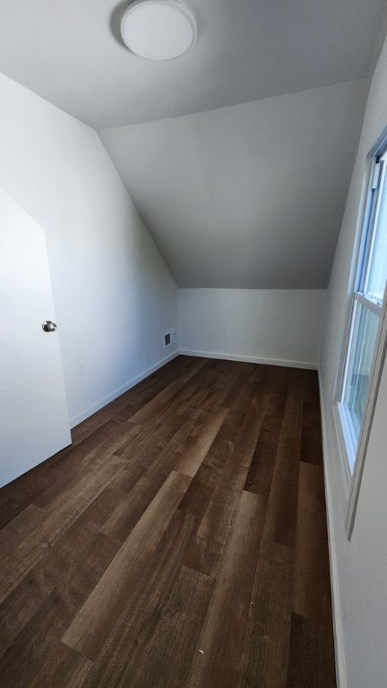 bonus room with lofted ceiling and dark wood-type flooring