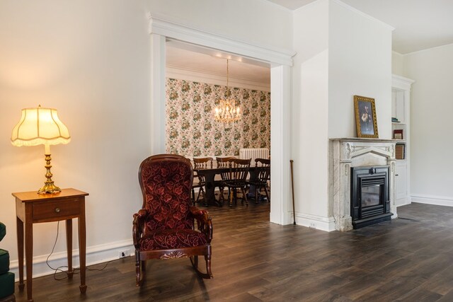 living area with crown molding, dark hardwood / wood-style floors, and an inviting chandelier