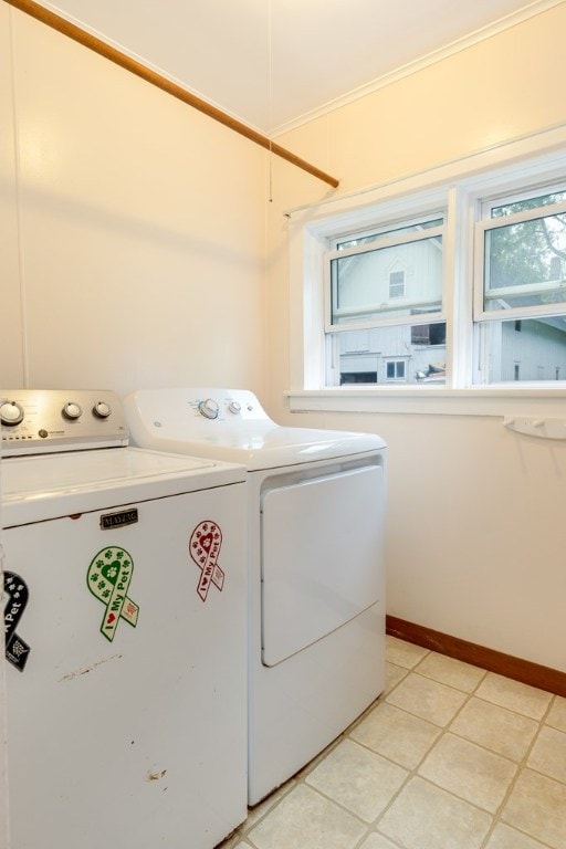 clothes washing area with ornamental molding and washing machine and dryer