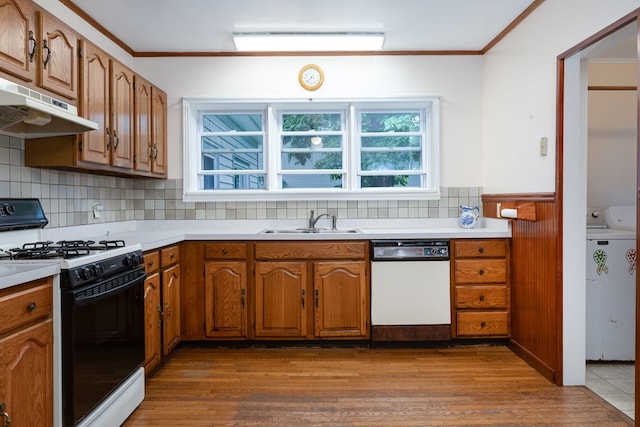 kitchen with dishwasher, sink, ornamental molding, gas range, and washer and clothes dryer