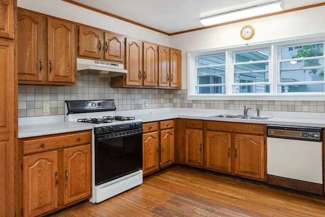 kitchen with white dishwasher, gas range oven, sink, and decorative backsplash