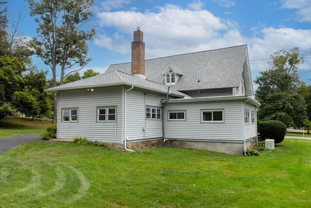 rear view of property featuring a lawn