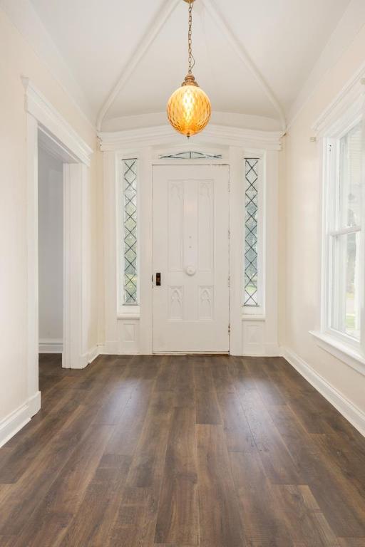 entryway with lofted ceiling and dark wood-type flooring