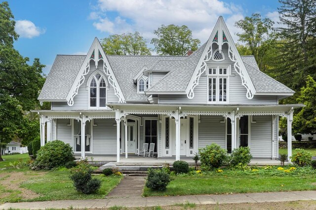 victorian house with a front yard and covered porch