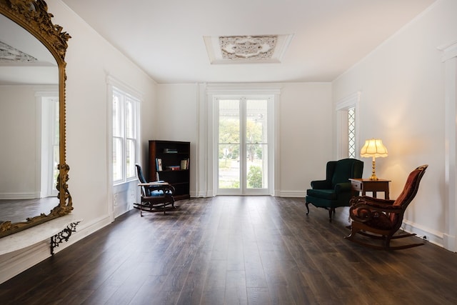 sitting room featuring ornamental molding and dark wood-type flooring